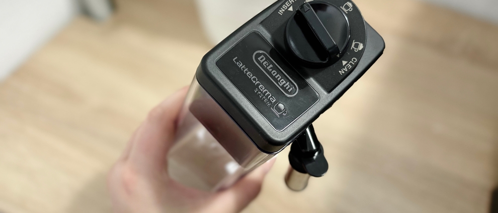 Der LatteCrema-Milchbehälter des De'Longhi Dinamica (ECAM350.55.B) wird von oben gezeigt. Die Bedieneinheit am Deckel bietet verschiedene Optionen.