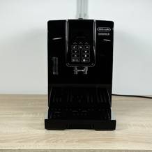 Die De'Longhi Dinamica (ECAM350.55.B) steht einsatzbereit auf einer Holzoberfläche. Das schwarze Design ist modern und kompakt.