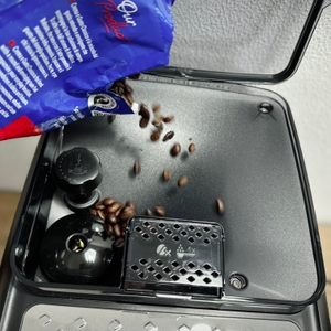 In das Bohnenfach des Philips Series 5400 (EP5447/90) werden Kaffeebohnen eingefüllt. Der Deckel ist geöffnet und zeigt die Einfüllöffnung.