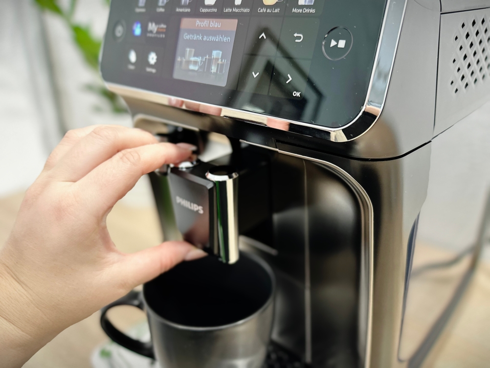 Die Höhe des Kaffeeauslaufs am Philips Series 5400 (EP5447/90) wird mit der Hand angepasst. Die Düse lässt sich stufenlos verstellen.