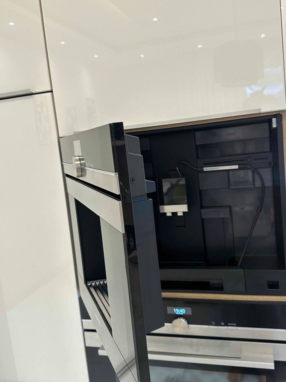 An einem getesteten Einbau-Kaffeevollautomaten ist die Tür geöffnet mit Blick in das Innere.