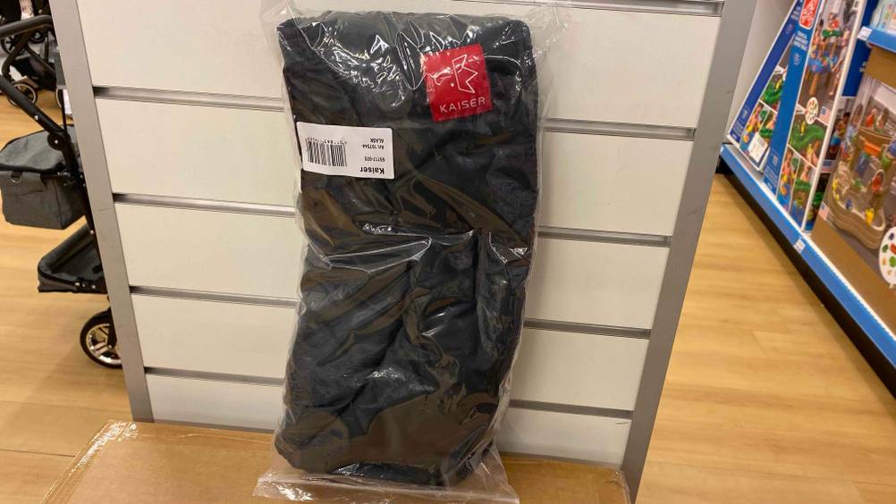 Kinderwagen-Handwärmer getestet: Ein verpacktes Produkt lehnt an einer hellen Wand.