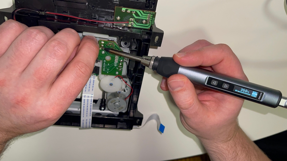 Ein Kaiweets KETS02 Lötkolben wird an einer Platine in einem geöffneten Gerät verwendet. Auf dem Display des Lötkolbens ist eine Temperatur von 350 °C eingestellt.