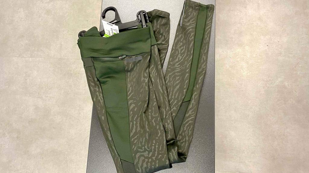 Kompressions-Laufhose Damen Test: Eine gefaltete Kompressions-Laufhose für Damen liegt auf einer dunklen Bank.