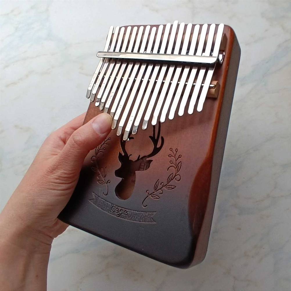 Eine Hand hält eine getestete Kalimba mit vielen Tasten. 