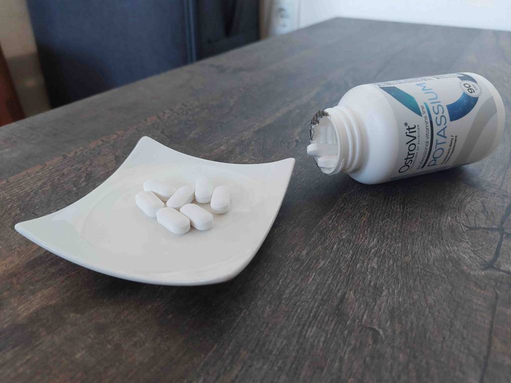 Auf einem Tisch befindet sich eine Schüssel mit sechs getesteten Kalium-Kapseln neben der geöffneten Packung.