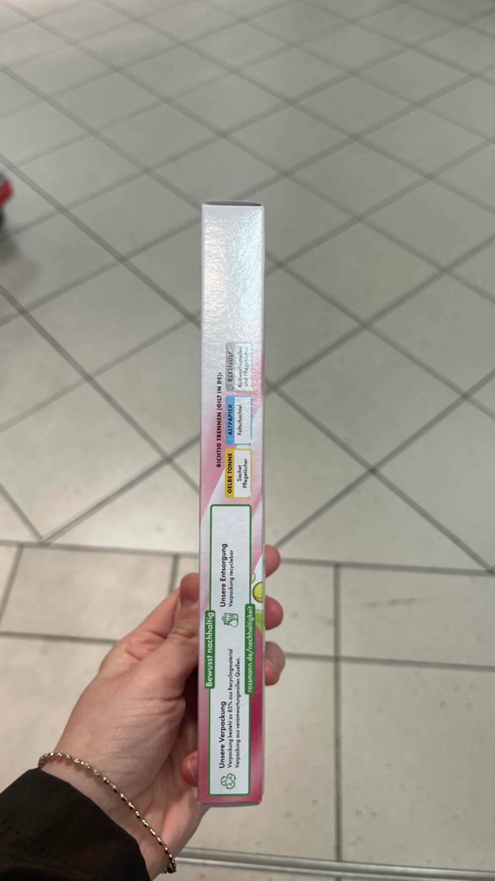 Im Test: Eine Hand zeigt die Seite mit Informationen einer Packung Kaltwachsstreifen.
