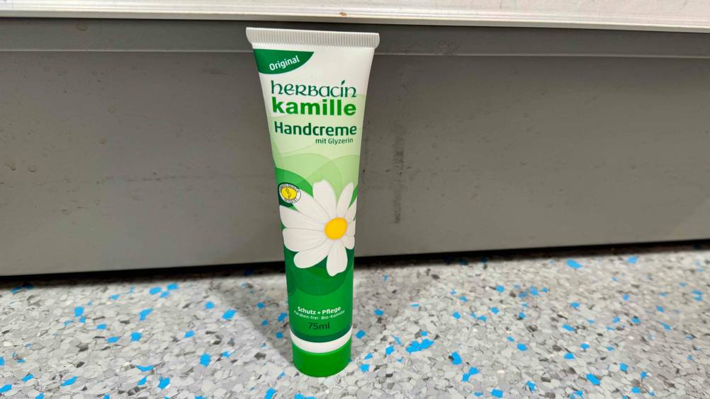Kamille-Handcreme-Test: Eine Tube vor einer grauen Fläche stehend.