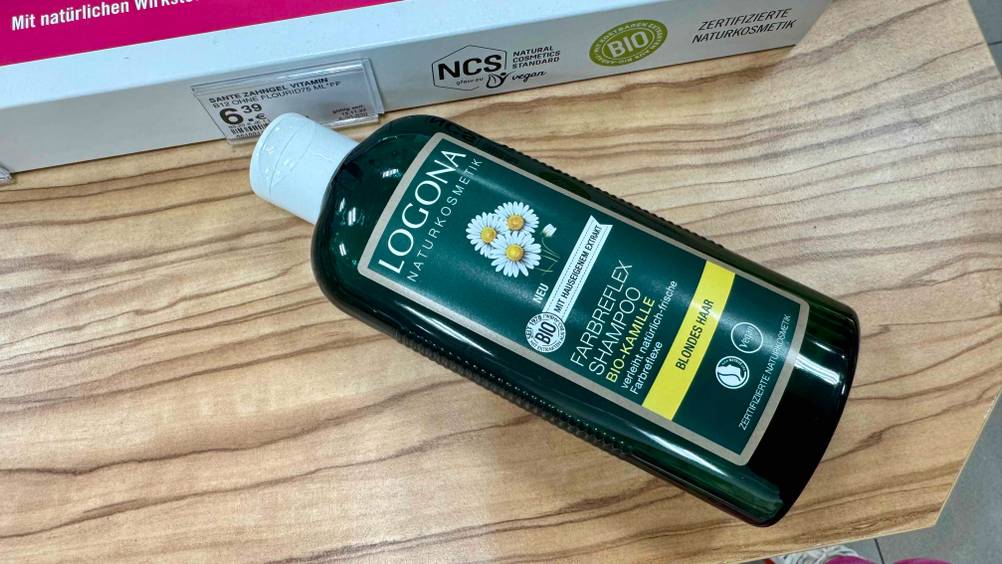Eine Flasche des getesteten Kamille-Shampoo horizontal auf einer Holzfläche.