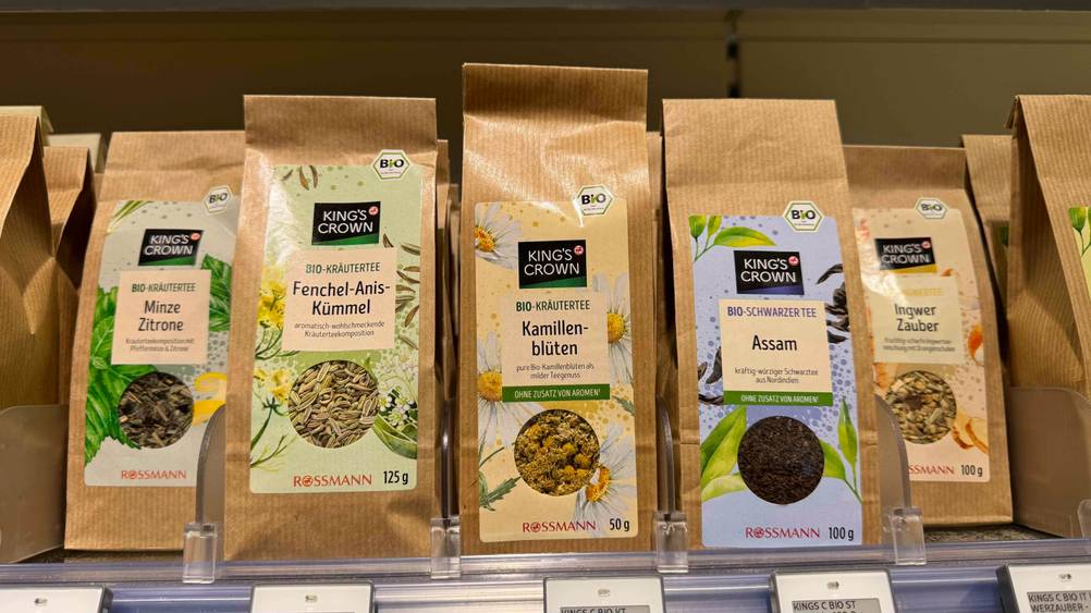 Mehrere Packungen der getesteten Kamillenblüten in einem Verkaufsregal neben anderen Produkten.