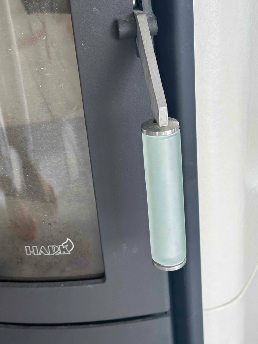 Detailansicht des Griffs der unteren Tür eines getesteten Kaminofens wasserführend.