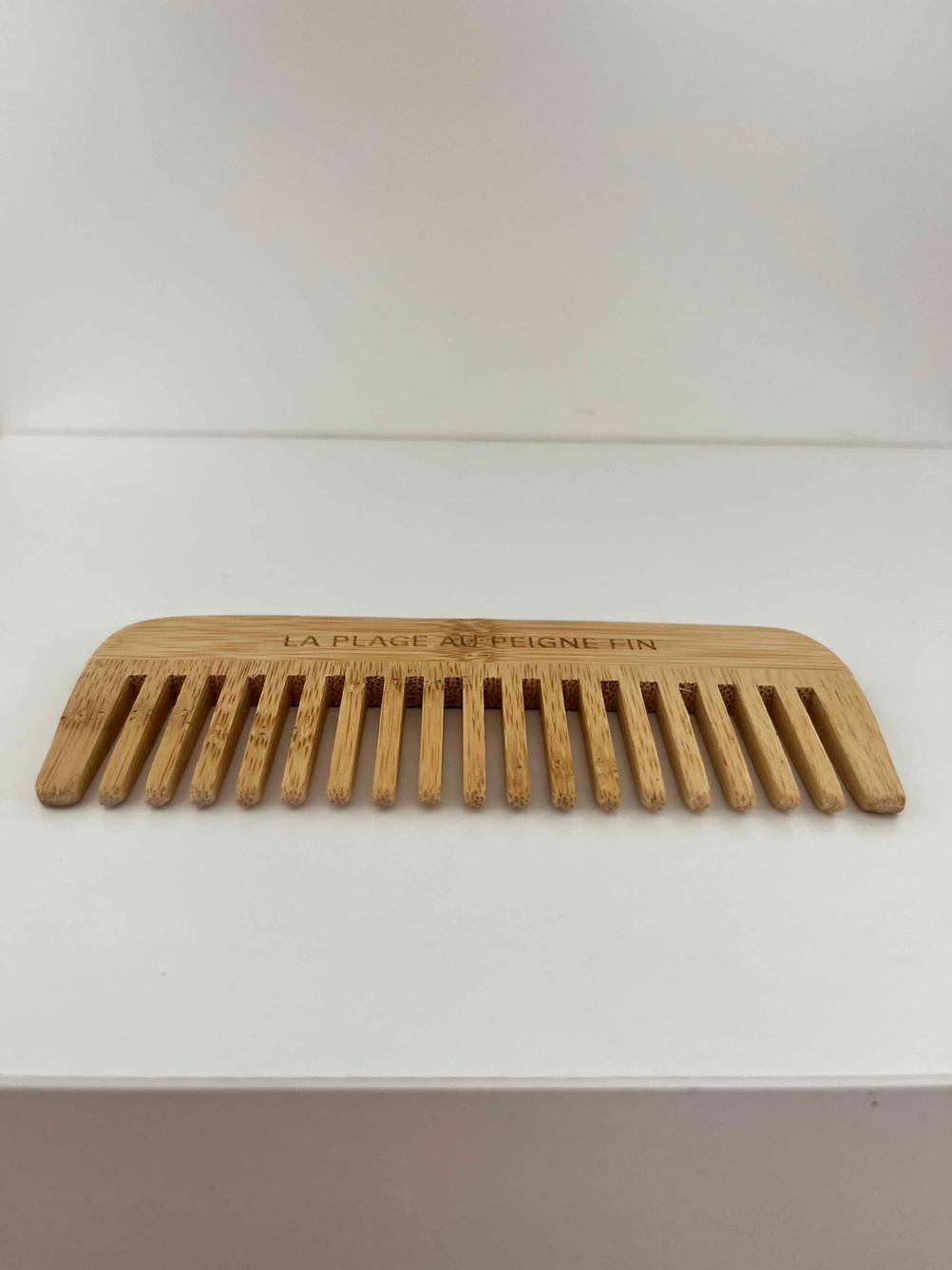 Ein Kamm im Test mit den Zinken nach vorne auf einer hellen Fläche.