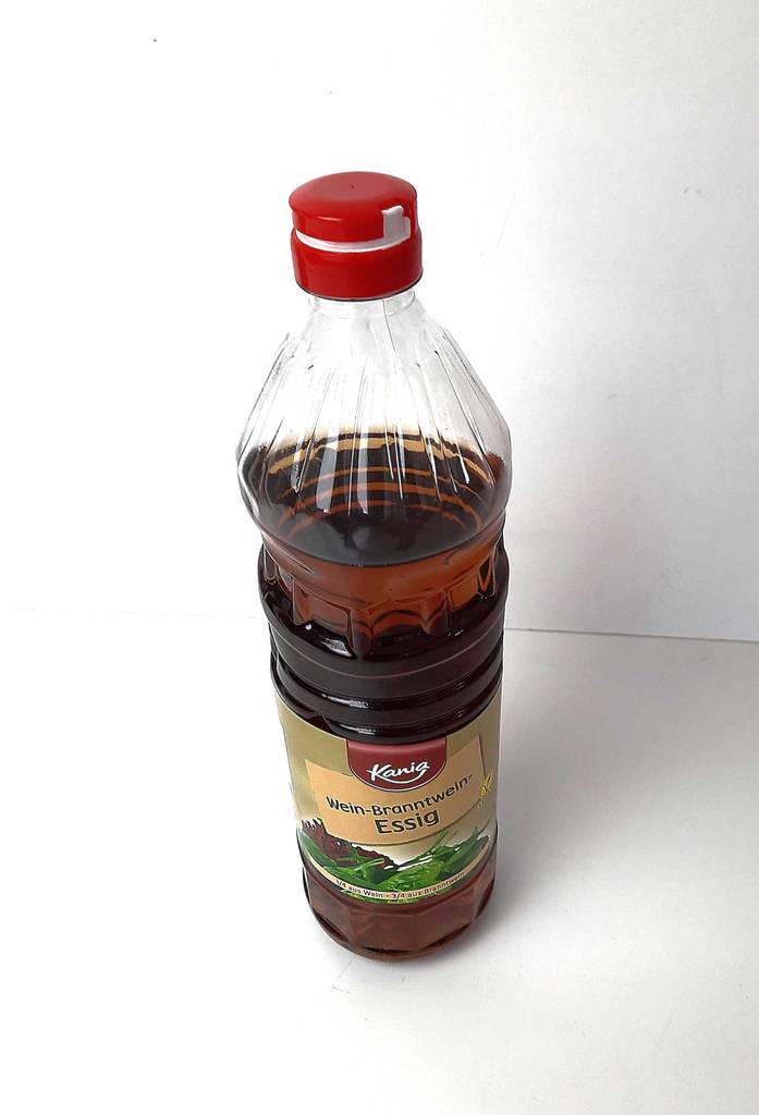 Testen: Branntweinessig in einer Kunststoffflasche steht von oben betrachtet vor einem weißen Hintergrund.