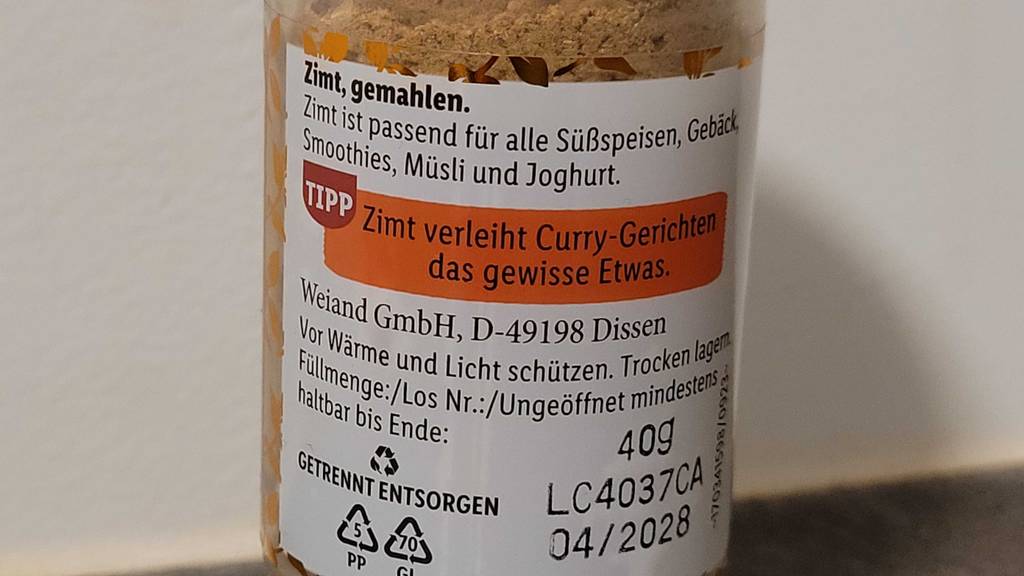 Zimtpulver im Test: Detailansicht der Produktbeschreibung auf einer transparenten Dose.