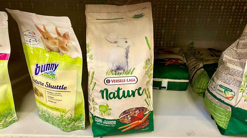 Mehrere getestete Kaninchenfutter-Packungen stehen in einem Geschäftsregal.