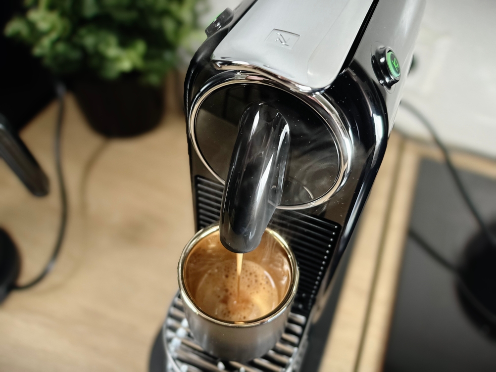 Ein Espresso läuft in eine kleine Tasse unter der De’Longhi Citiz. Der Brühvorgang ist in vollem Gange.