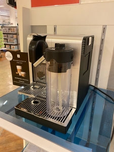 Getestet: Eine Kapselmaschine von schräg seitlich auf einer blauen Fläche in einem Verkaufsladen.