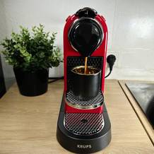 Espresso läuft aus der Krups Nespresso XN7415 Citiz in eine Tasse. Der Brühvorgang ist im Gange.