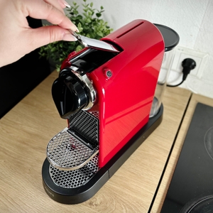 Eine Nespresso-Kapsel wird von oben in die Krups XN7415 Citiz eingelegt. Der Hebel ist offen.