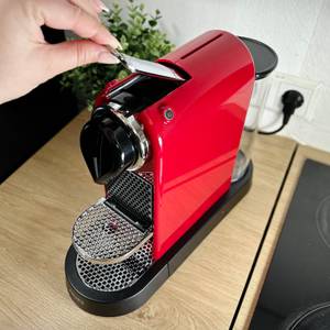 Eine Nespresso-Kapsel wird von oben in die Krups XN7415 Citiz eingelegt. Der Hebel ist offen.