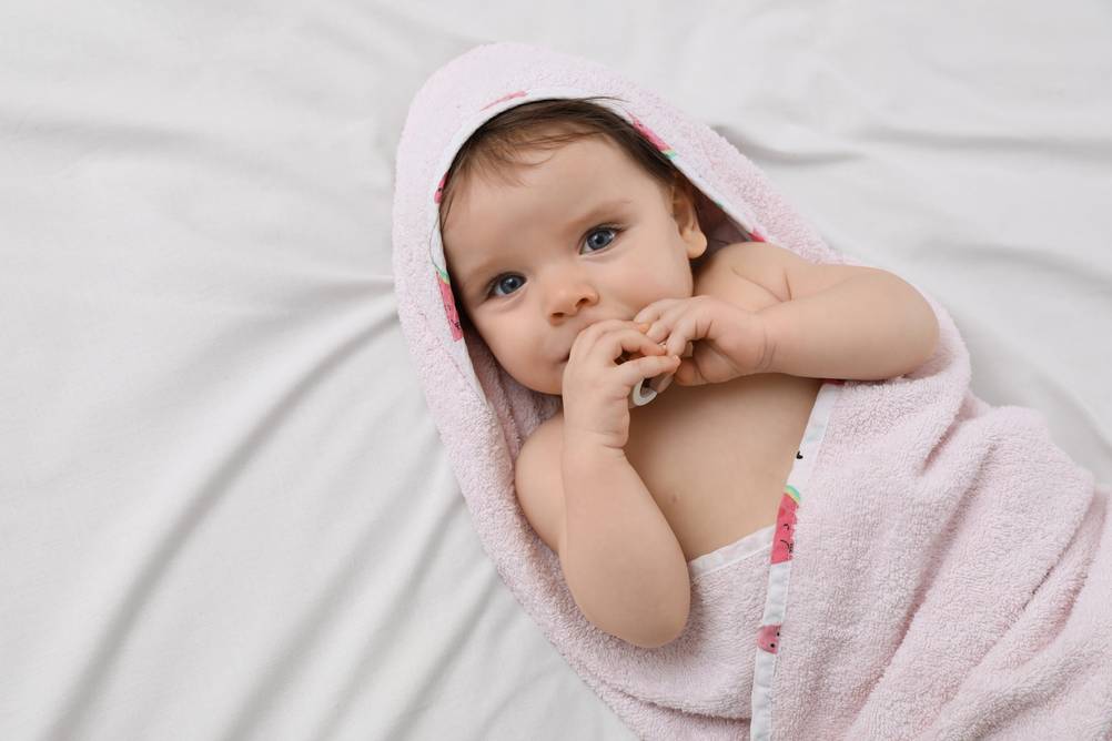 Kapuzenhandtuch im Test: In rosa Kapuzenhandtuch eingewickeltes Baby