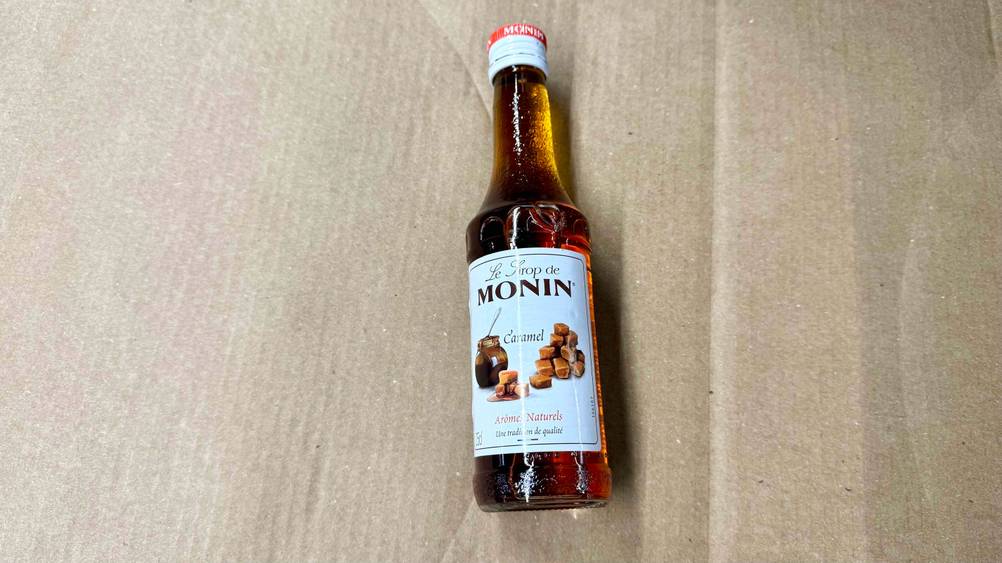 Auf einem Karton liegt eine Flasche des Karamell-Sirups im Test.