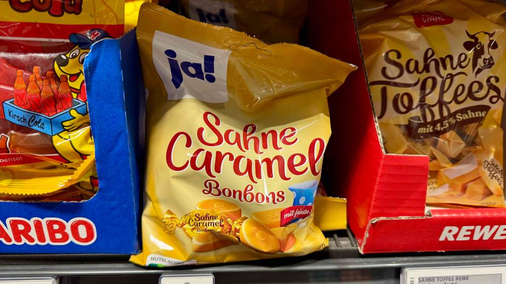 Mehrere Packungen der Karamellbonbons im Test in einem Verkaufsregal.