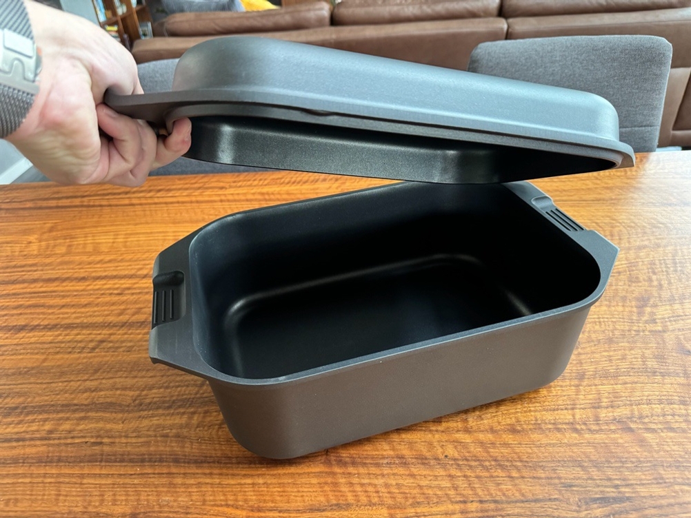 Eine Hand hebt den Deckel des Karcher-Aluguss-Bräter 2-in-1 hoch