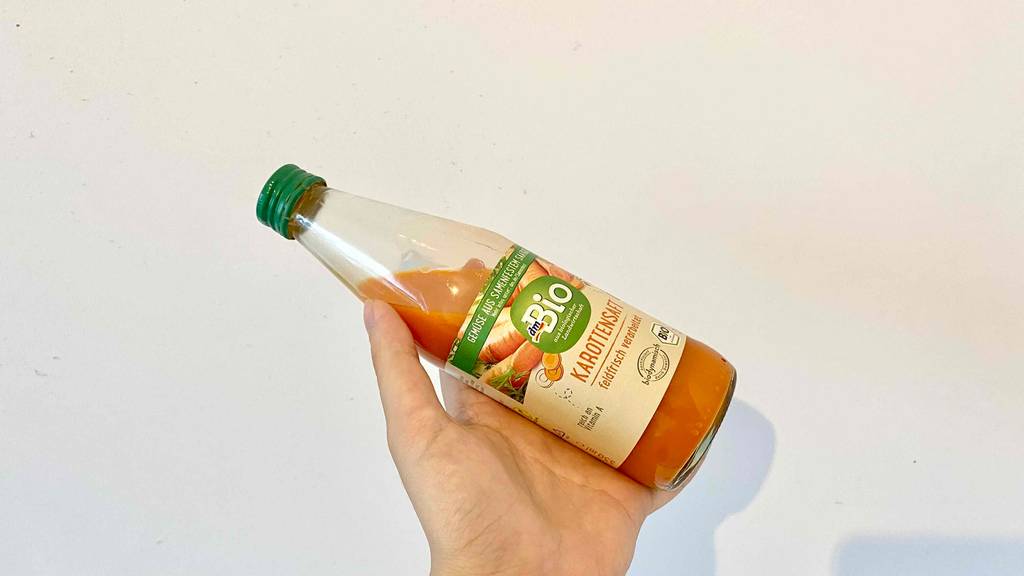 Karottensaft Flasche in der Hand