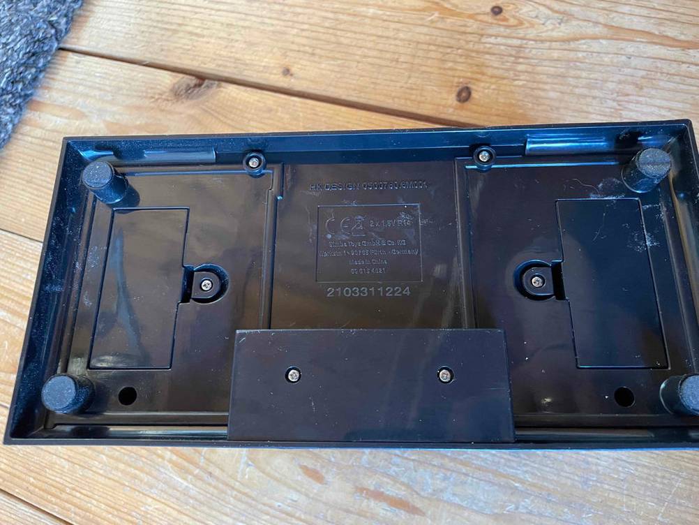 Auf einer Holzoberfläche liegt die Rückseite von einer getesteten Kartenmischmaschine.