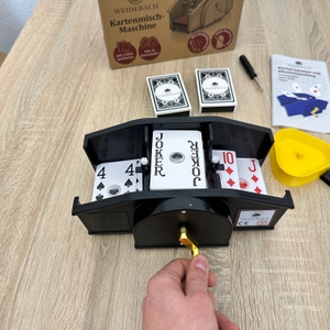 Eine Weidebach-Kartenmischmaschine zeigt den Mischvorgang mit sichtbaren Spielkarten im Inneren des Geräts.