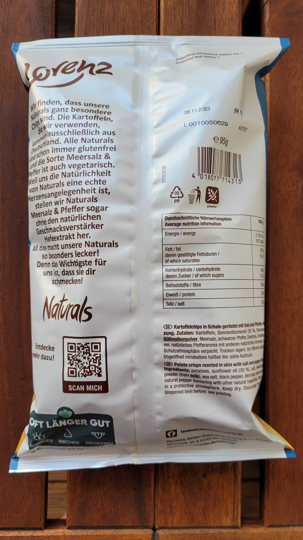 Rückseite einer Packung Kartoffelchips auf einem Holztisch.