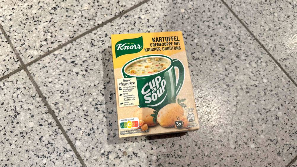 Die getestete Kartoffelsuppe liegt verpackt auf einem Fließenboden.