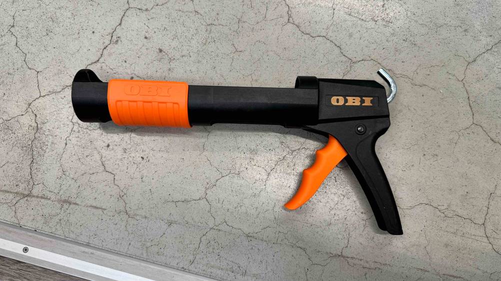 Auf einem Betonboden liegt eine Kartuschenpresse im Test.