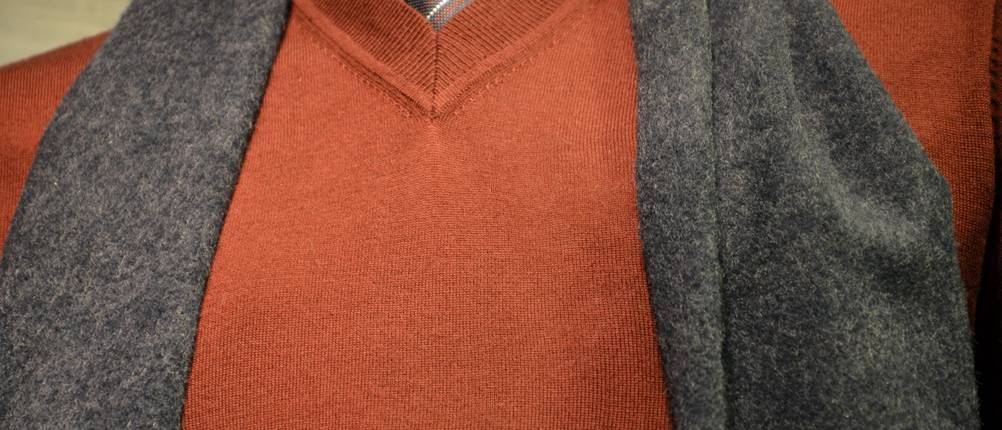 Kaschmir-Schal-Test: Mann trägt grauen Schal über orangen Pullover