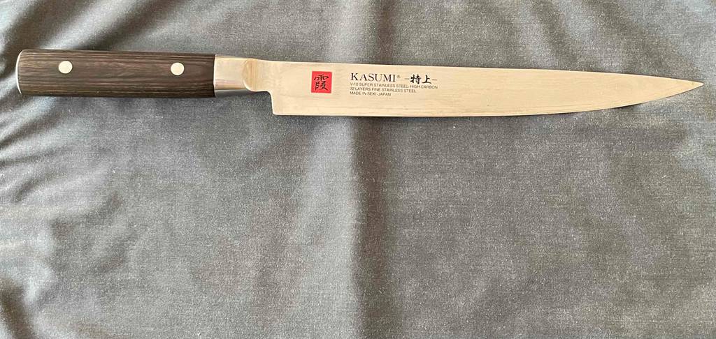 Chinesisches Kochmesser im Test: Ein Messer von KASUMI liegt auf grauem Stoff.