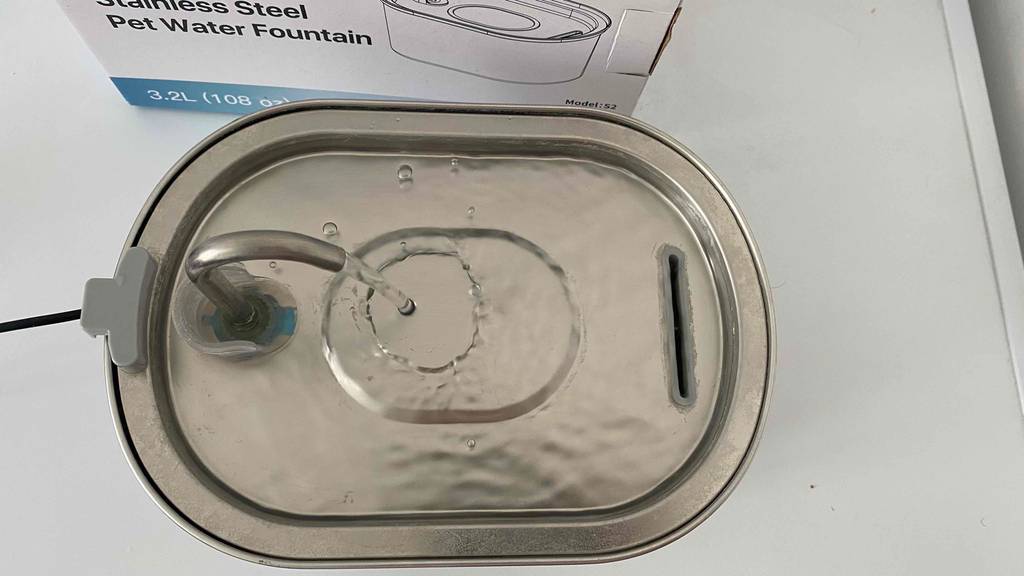 Laufender Katzenbrunnen neben Verpackung.
