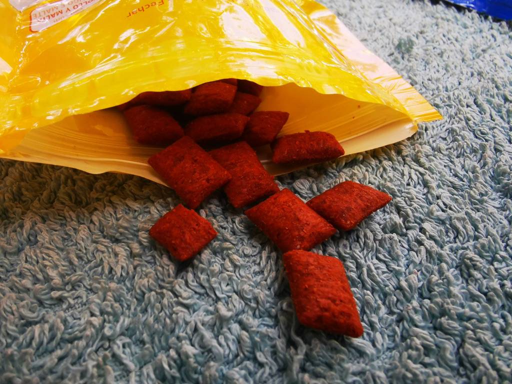 Mehrere Katzenleckerlies liegen zum testen vor der geöffneten Verpackung.