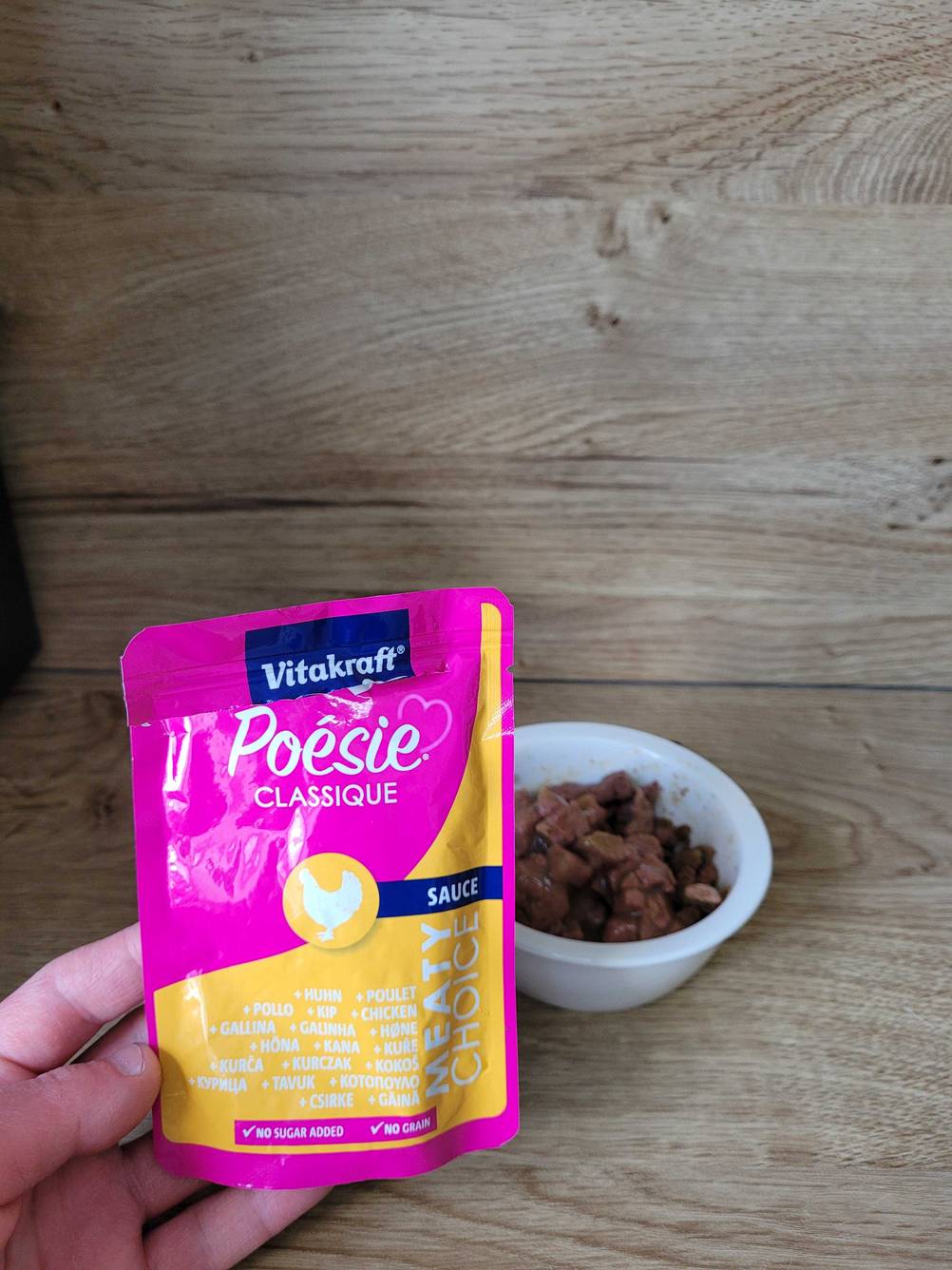 Katzennassfutter-Test: Eine Hand hält eine Tüte des Katzennassfutters von Vitakraft.