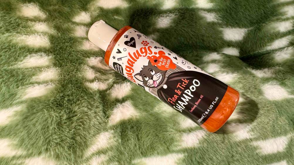 Ein getestetes Katzenshampoo auf einer grün-weißen Stofffläche.