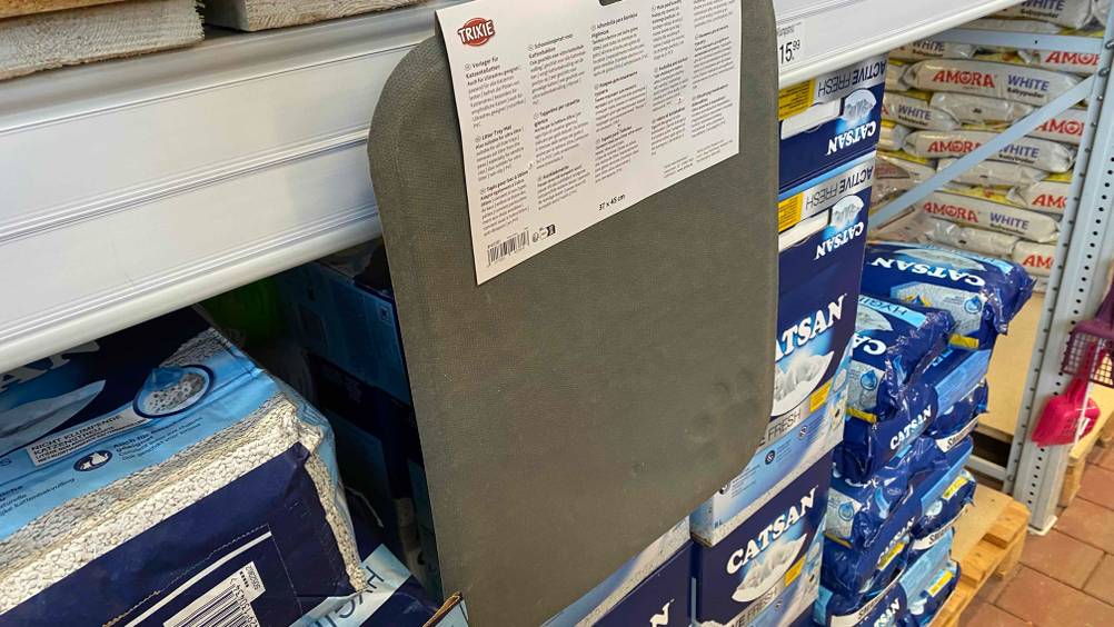 Katzenstreu-Matte getestet: Ein Produkt hängt mit der Rückseite nach vorne an einem Verkaufsregal, im Hintergrund andere Produkten.