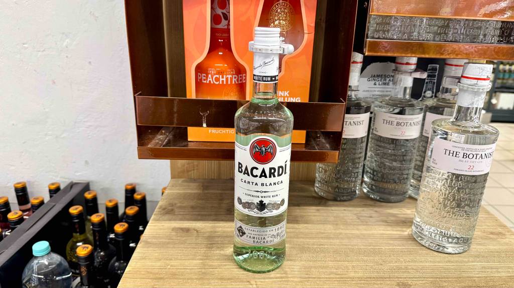Eine Flasche mit Bacardí im Test steht auf einem Holzregal neben weiteren Spirituosen.