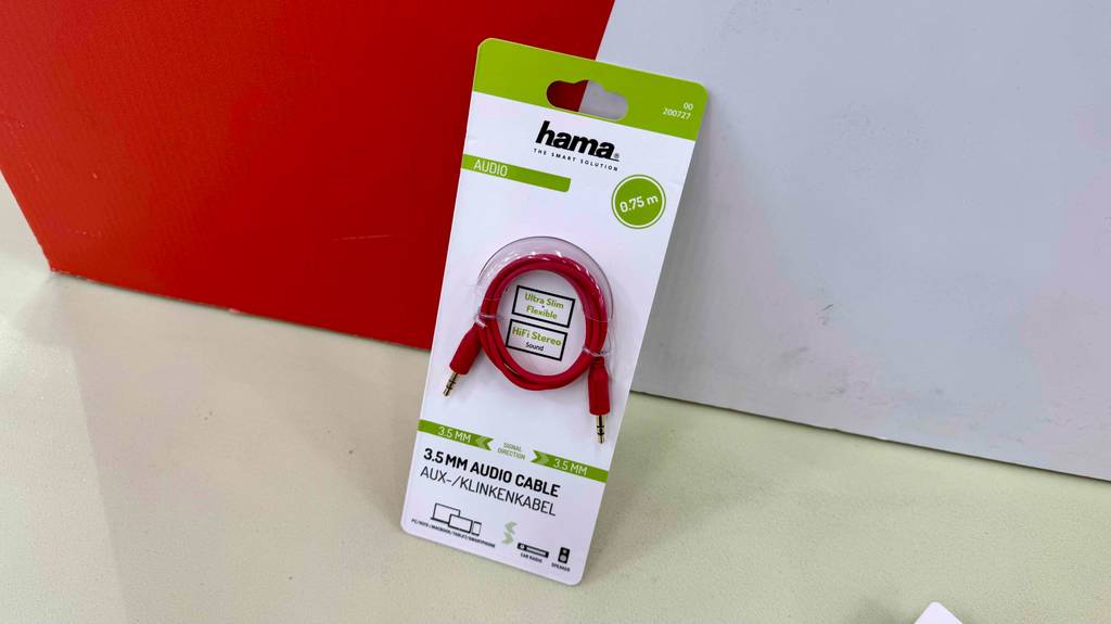 Im Test: Ein Aux-Kabel in der Verpackung lehnt vor einem roten Hintergrund