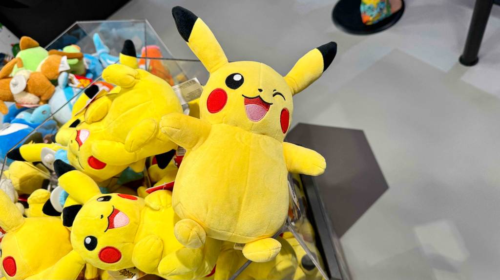 Im Test: Ein Pokémon-Kuscheltier in Gelb liegt auf einem Haufen gelber Kuscheltiere im Geschaäft.