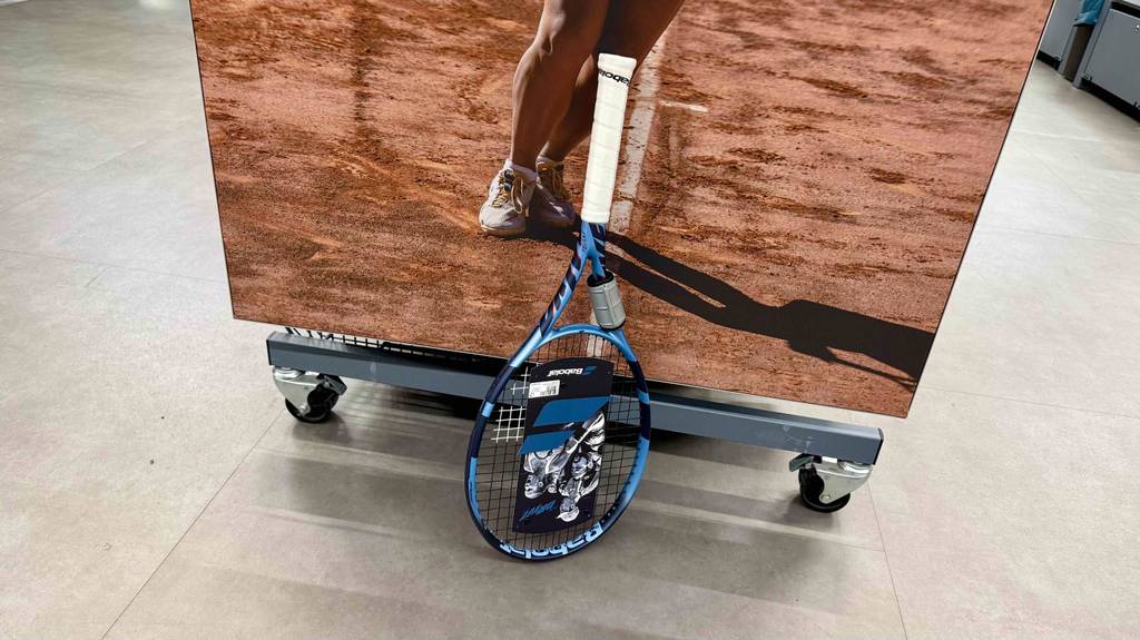 Getestet: Ein Babolat-Tennis-Schläger lehnt an einem Verkaufsregal.