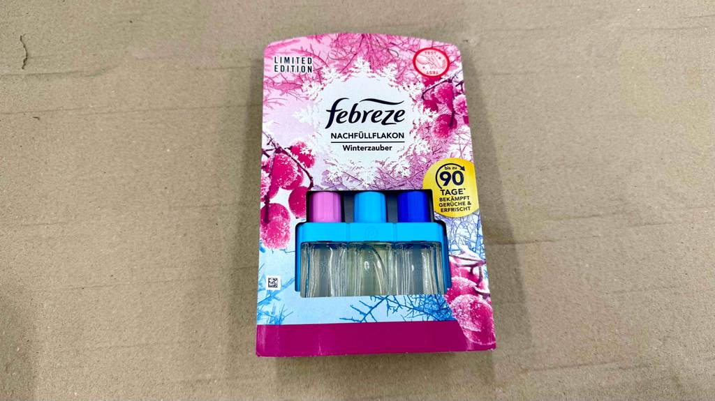 Febreze-Duftstecker Vergleich: Ein Verpackung inklusive eines Febreze-Duftstecker im Test liegt auf einem beigefarbenen Untergrund.