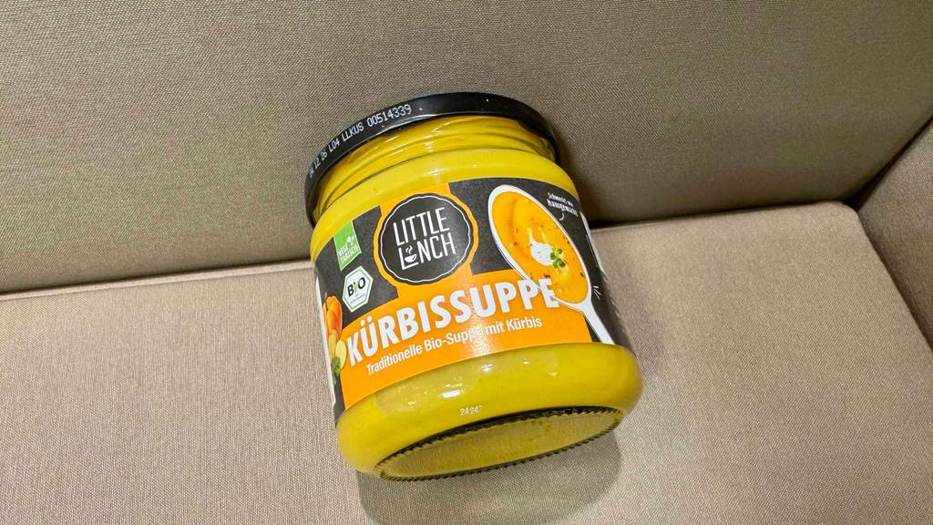 Im Test: Eine Little-Lunch-Kürbissuppe im Glas liegt auf einer beigefarbenen Oberfläche.