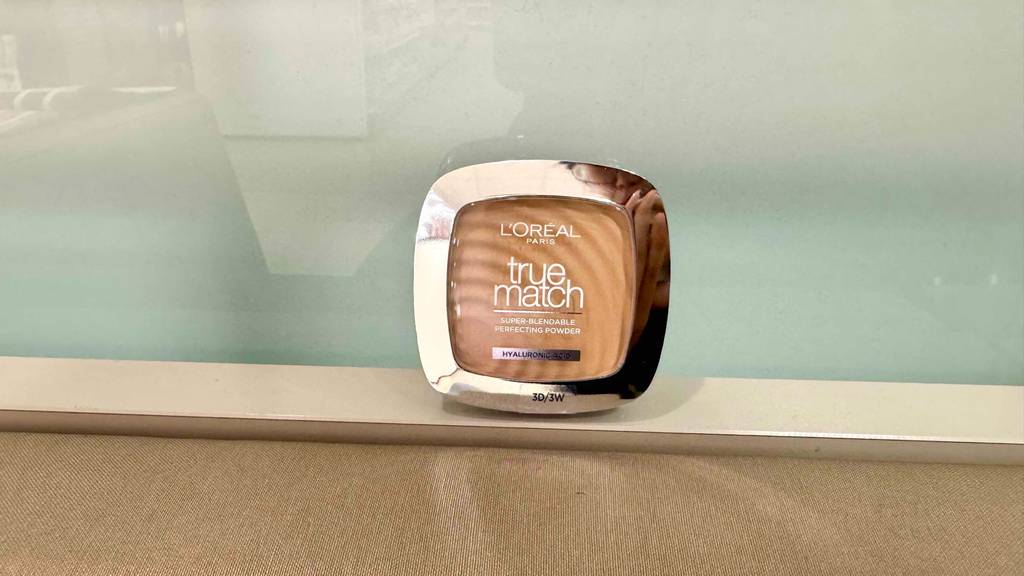 L'Oréal-Puder im Test steht vor einer Glaswand.