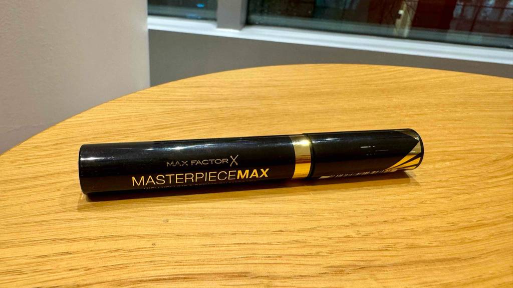 Max-Factor-Mascara im Test: Ein schwarzer Stift liegt auf einer Holzfläche.