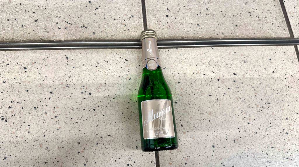 Im Test: Mumm Sekt in der Portionsflasche liegt auf dem Boden..